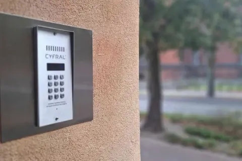 Domofon Cyfral na ścianie budynku. Aby wejść, trzeba wiedzieć, jak wpisać kod do klatki.