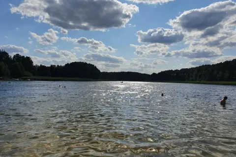 Słoneczny dzień nad jeziorem w Złotnikach Kujawskich. Kąpiel w chłodnej wodzie, otoczonej zielonym lasem, to idealny relaks.