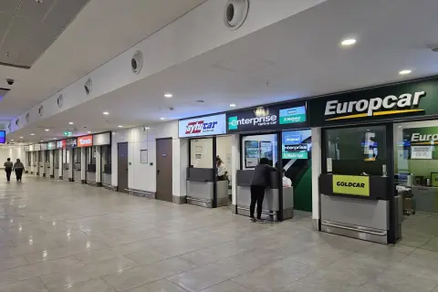 Kasa wypożyczalni samochodów na lotnisku w Antalyi. Widać szyldy Europcar, Enterprise, Avis i innych.