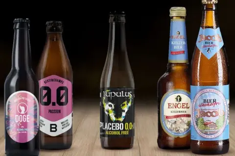 Cinque bottiglie di birra analcolica, tra cui una con etichetta "Doge IPA" e un'altra "Placebo 0,0%", perfette per chi cerca un'alternativa senza alcol, anche se non sono birra 10 gradi.