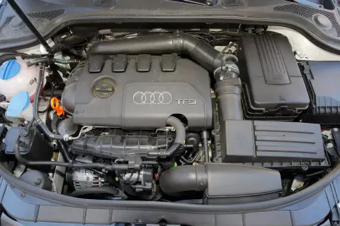 Silnik TFSI w Audi 8P. Widoczne elementy układu dolotowego, zbiornik płynu chłodniczego i alternator.