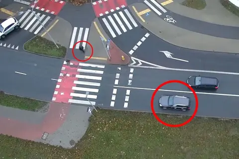 Osoba na przejściu dla pieszych, samochody czekają.