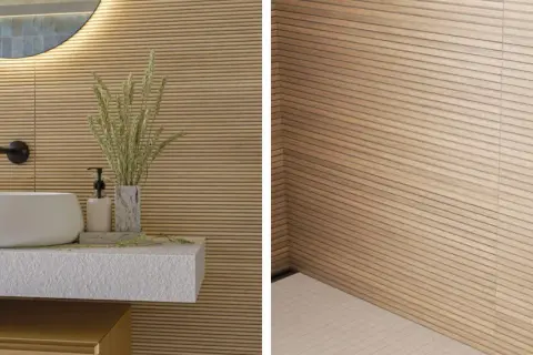 Idée carrelage petite salle de bain : mur texturé imitation bois clair, lavabo rond blanc, robinetterie noire. Ambiance zen et naturelle.