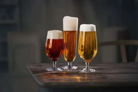 Tre bicchieri di birra, uno ambrato, uno dorato e uno più scuro, con schiuma abbondante. Il loro significato? La birra lager è un mondo di sapori da esplorare.