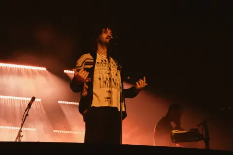 Kevin Parker z Tame Impala na koncercie w Gliwicach, w świetle reflektorów.