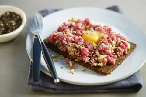 En läcker råbiff på mörkt bröd med en gul äggula i mitten. Perfekt för dig som söker ett gott råbiff recept.