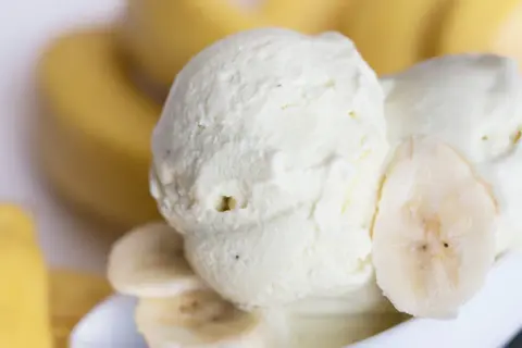 Cremiges Bananen Eis mit frischen Bananenscheiben, ein Genuss für heiße Tage.