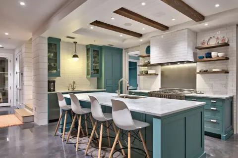 Cucina moderna con isola centrale, sgabelli bianchi e mobili color petrolio. La scelta tra meglio vernice opaca o lucida per i pensili è un dettaglio che fa la differenza.