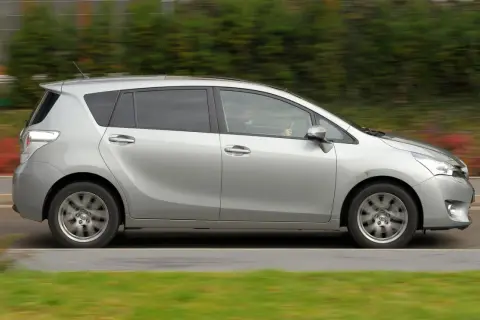 Srebrna Toyota Verso w ruchu. Zastanawiasz się nad jej wadami i zaletami? Ten rodzinny minivan oferuje przestronne wnętrze i komfort.