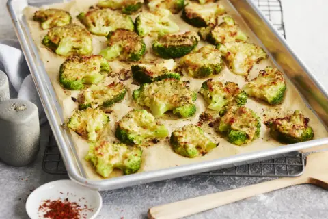 Gerösteter Brokkoli mit Käse auf einem Backblech. Perfekt zum **Brokkoli braten** für eine gesunde Beilage.