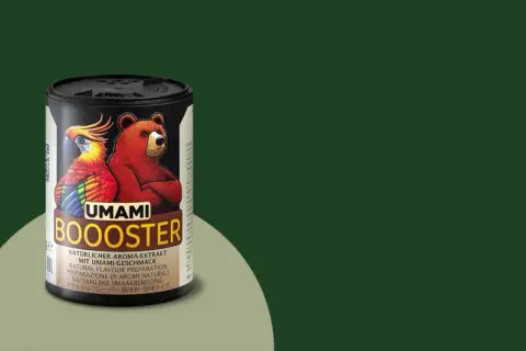 Dose mit Bär und Papagei, die "UMAMI BOOOSTER" bewirbt. Natürlicher Aroma-Extrakt, der an fermentierte Bohnen erinnert.