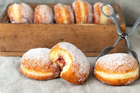 Frisch gebackene Berliner, mit Zucker bestreut, warten auf ihre Füllung. Ein köstliches berliner rezept.