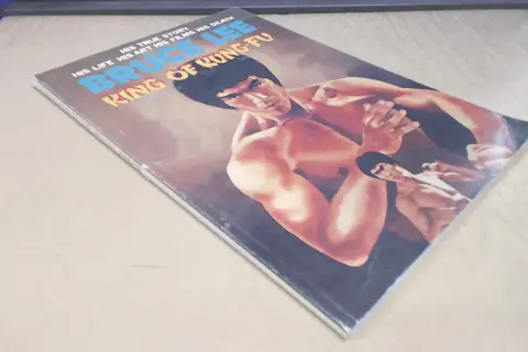 Okładka komiksu "Bruce Lee: Król Kung Fu". Widoczny Popek Franek w kimonie, w pozie bojowej.