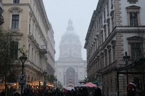 Śnieg pada na ulicach Budapesztu, tworząc zimowy klimat. W tle widać Bazylikę św. Stefana.