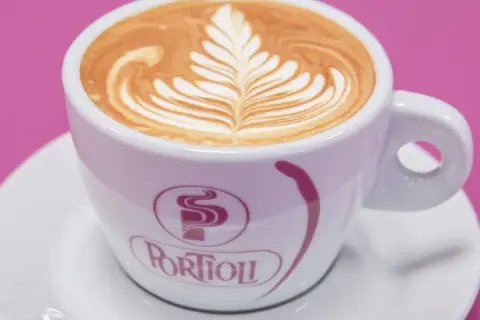Un cappuccino con latte art a forma di foglia, uno dei tanti tipi di cappuccino che deliziano gli occhi e il palato.