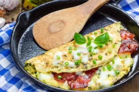 Pyszny omlet z serem, pomidorami i szczypiorkiem na patelni. Idealny omlet przepis na śniadanie.