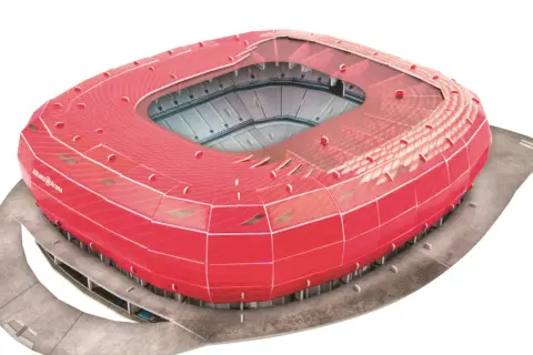 Czerwony, futurystyczny stadion Allianz Arena, często uznawany za najładniejszy stadion na świecie, z widokiem na trybuny.