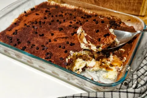 Un délicieux tiramisu ricotta, saupoudré de cacao et de pépites de chocolat, prêt à être dégusté.