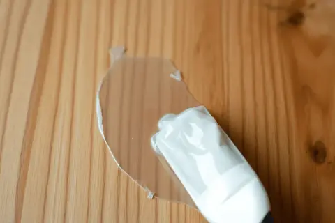 Une nouvelle lasure transparente recouvre une ancienne lasure sur un bois clair.