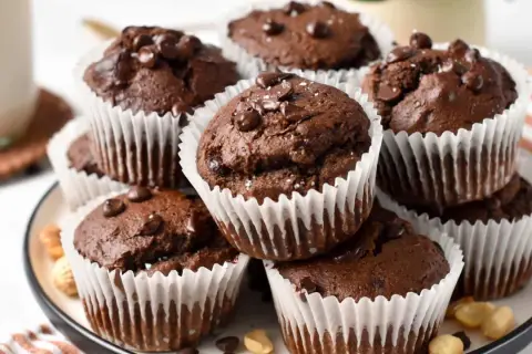 Schokoladen-Protein-Muffins mit Schokostückchen und einer Prise Salz, appetitlich gestapelt.