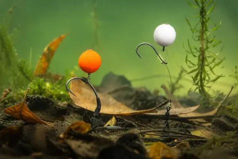 Zwei Pop-Up-Montagen mit orangefarbenen und weißen Kugeln, bereit für den Fang im Unterwasser-Dschungel.