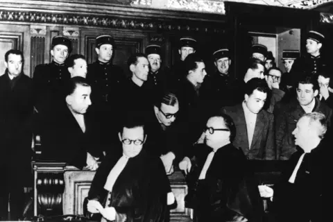Procès en France, des hommes en uniforme et des avocats en robe. Une scène qui pourrait illustrer l'évolution de la délinquance en France depuis 1950.