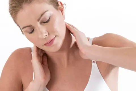 Femme se massant le cou, peut-être pour muscler son cou ou soulager une tension.