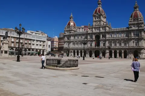 La **plaza María Pita** luce soleada con su ayuntamiento monumental y gente paseando.