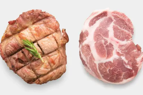 Zwei Schweinefleischstücke: eines roh mit Marmorierung, das andere gegrillt mit Rosmarin. Ist Schweinefleisch ungesund?