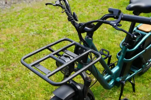Zielony rower elektryczny dla seniora z dużą platformą bagażową z przodu i wygodnym siodełkiem. Idealny na zakupy i wycieczki.