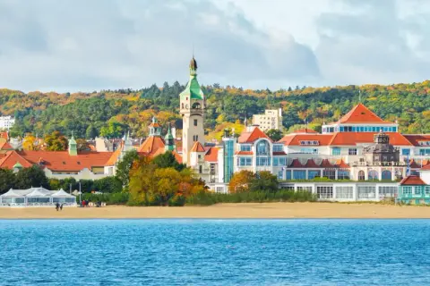 Sopot co warto zobaczyć: malowniczy widok na plażę, morze i zabytkowe budynki z charakterystyczną wieżą.