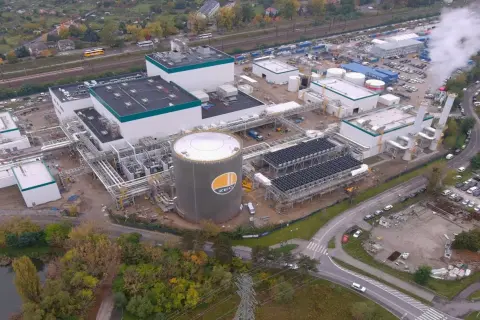 Budowa nowoczesnej elektrociepłowni, gdzie Polimex-Mostostal realizuje akcje. Widoczny ogromny zbiornik ZEC, instalacje i kominy.