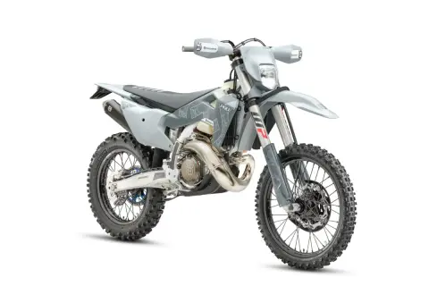 Szary motocykl Husqvarna z oponami terenowymi na białym tle.