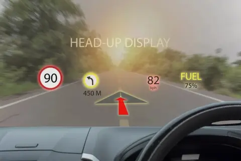 Head-up display cos'è: informazioni di guida proiettate sul parabrezza: limite 90, svolta a 450m, velocità 82 km/h, carburante 75%.