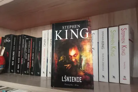 Półka pełna książek Stephena Kinga, w tym "Lśnienie", "Cmętarz zwierząt" i "Nocna zmiana".