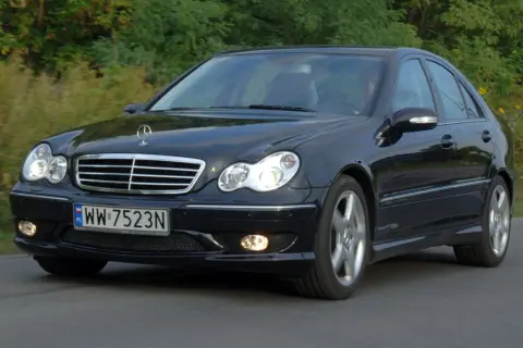 Czarny Mercedes W203 1.8 Kompressor w ruchu, z widocznym grillem i reflektorami.