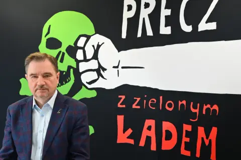 Mężczyzna na tle napisu "Precz z zielonym ładem". Kto podpisał zielony ład w Polsce?