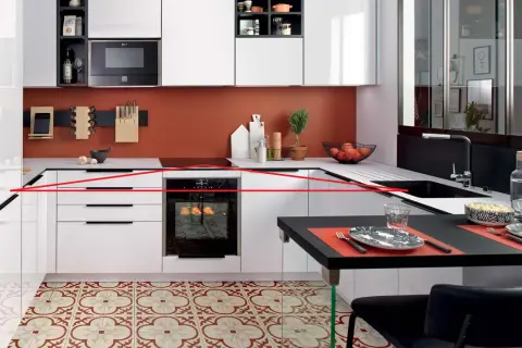 Cuisine moderne avec une organisation optimisée : tiroirs blancs, four encastré, crédence orange, et un îlot noir pour les repas.