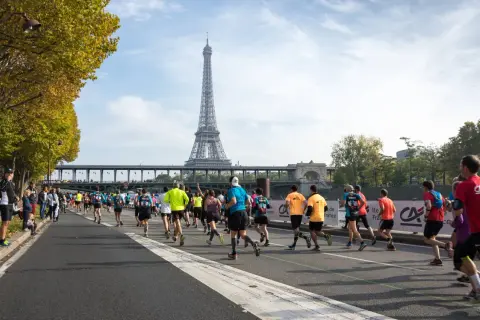 Course de marathon à Paris, avec la Tour Eiffel en arrière-plan. L'allure marathon 3h20 est visée par ces coureurs déterminés.