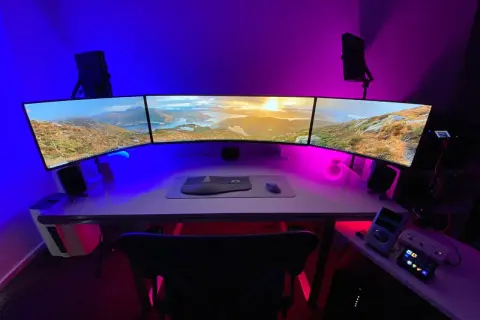 Nowoczesne stanowisko z trzema monitorami, klawiaturą i myszką. Dowiedz się, jak podłączyć monitor do laptopa, by stworzyć podobny setup.