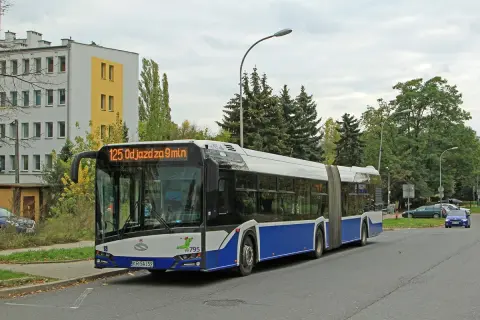 Autobus linii 125 odjeżdża za 9 minut. Długi, przegubowy pojazd stoi na przystanku obok budynku mieszkalnego.