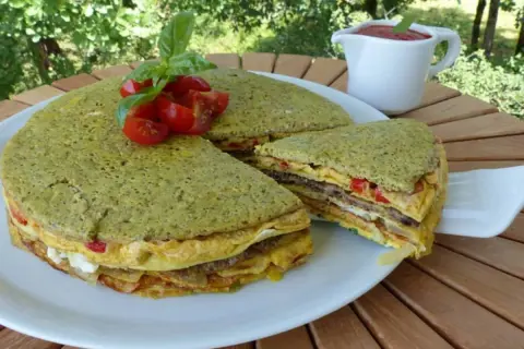 Le crespeou, une tourte verte aux couches d'omelette et de légumes, garnie de tomates et de basilic.
