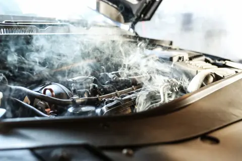 Dymiący silnik samochodowy, ilustrujący skutki przegrzania silnika aluminiowego a żeliwnego.