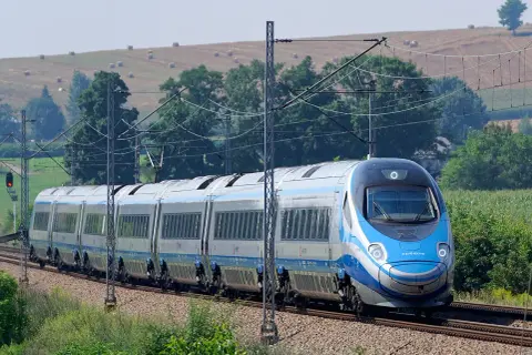 Pendolino na tle krajobrazu z sianem na wzgórzu.