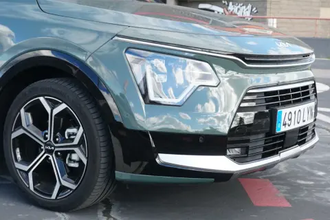 Detaljer från en kia niro hybrid test: framhjul, strålkastare och grill.