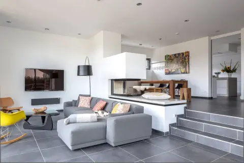 Modernes split-level Haus mit offenem Wohnbereich, Kamin, Essbereich und stilvoller Einrichtung.