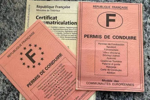 Deux permis de conduire français et un certificat d'immatriculation. L'un des permis est un "attestation de non conduite" pour la France.