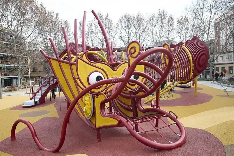 Un parque infantil con forma de dragón amarillo y rojo en Usera. ¡Un lugar genial que ver en Usera para los niños!
