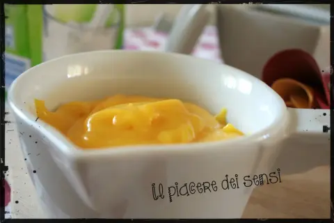 Crema pasticcera ricetta della nonna, densa e dorata, in una ciotola bianca. Un piacere per gli occhi e per il palato.