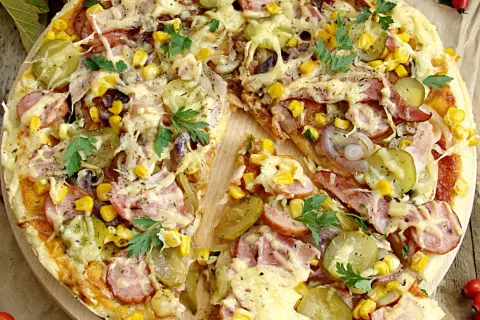 Pizza wiejska składniki: ser, kukurydza, ogórek kiszony, cebula, kiełbasa, szynka, natka pietruszki. Apetyczny widok!